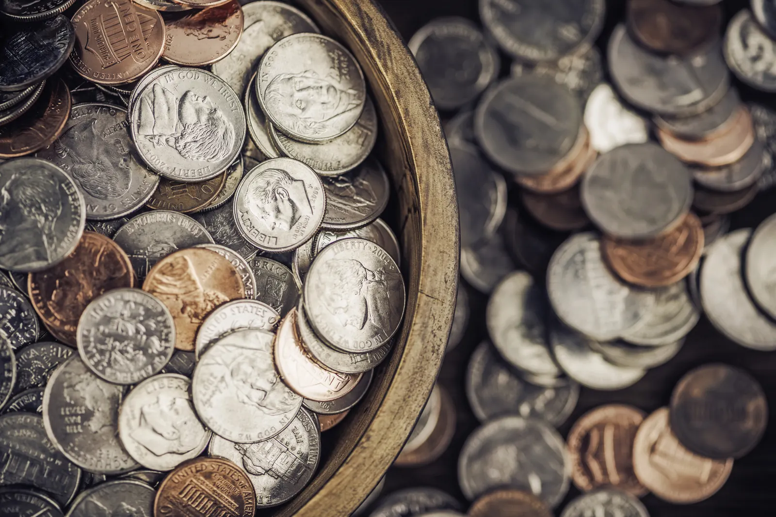 Wooden bowl filled with assorted American currency from a coin estate